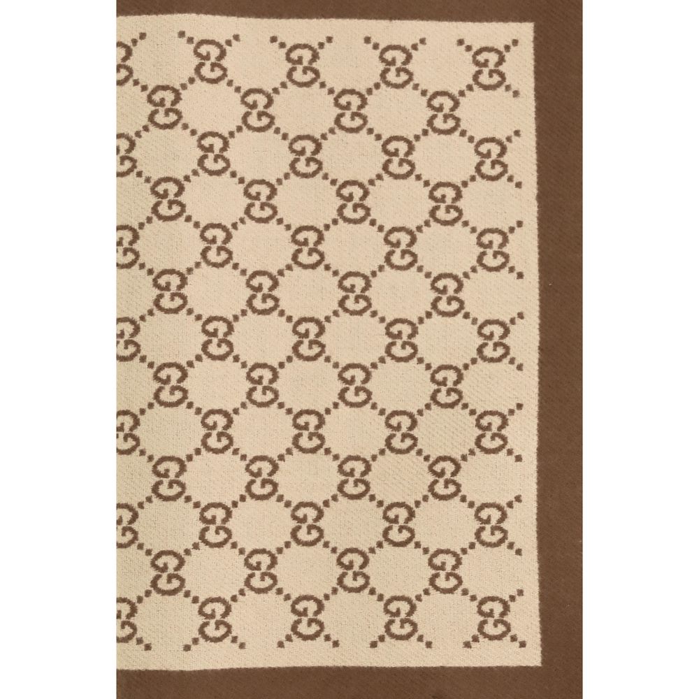 Elevate your style with the Gucci Beige Wool Oves Aries Scarf, crafted from 100% Merino wool, blending iconic design with timeless luxury for the discerning individual.