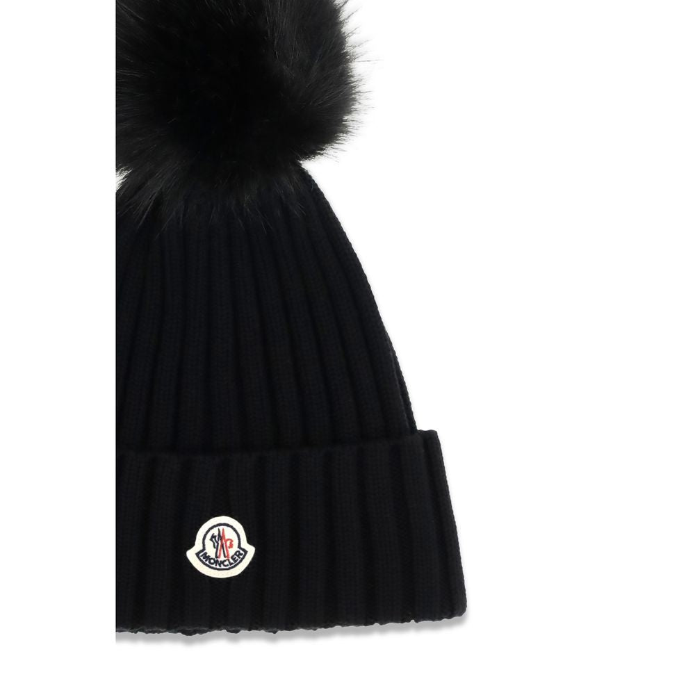 Indulge in the Moncler Black Wool Oves Aries Beanie, a masterpiece of virgin wool with rib-knit texture and refined pom pon detail, perfect for the discerning style connoisseur.