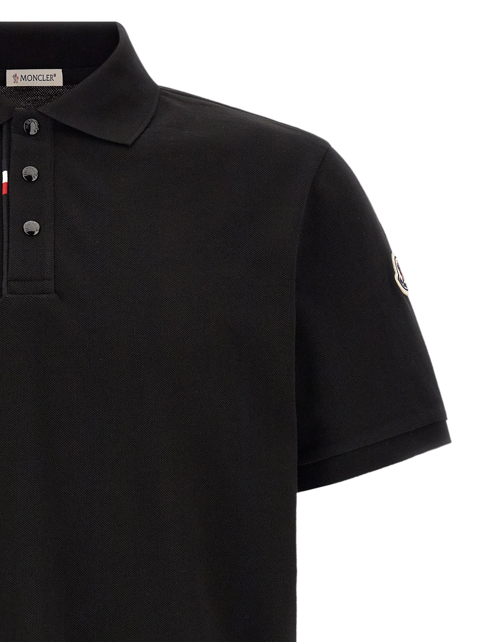 Experience the essence of luxury with the Moncler Black Cotton Polo Shirt, a masterpiece of craftsmanship that embodies sophistication and timeless elegance.