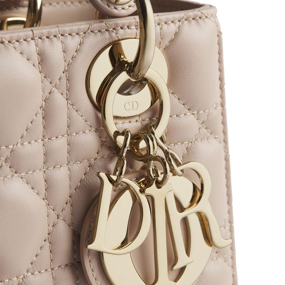 Discover the Dior Beige Lamb Leather Shoulder Bag, a testament to exquisite craftsmanship in powder beige Cannage lambskin, elevating your style with timeless luxury.
