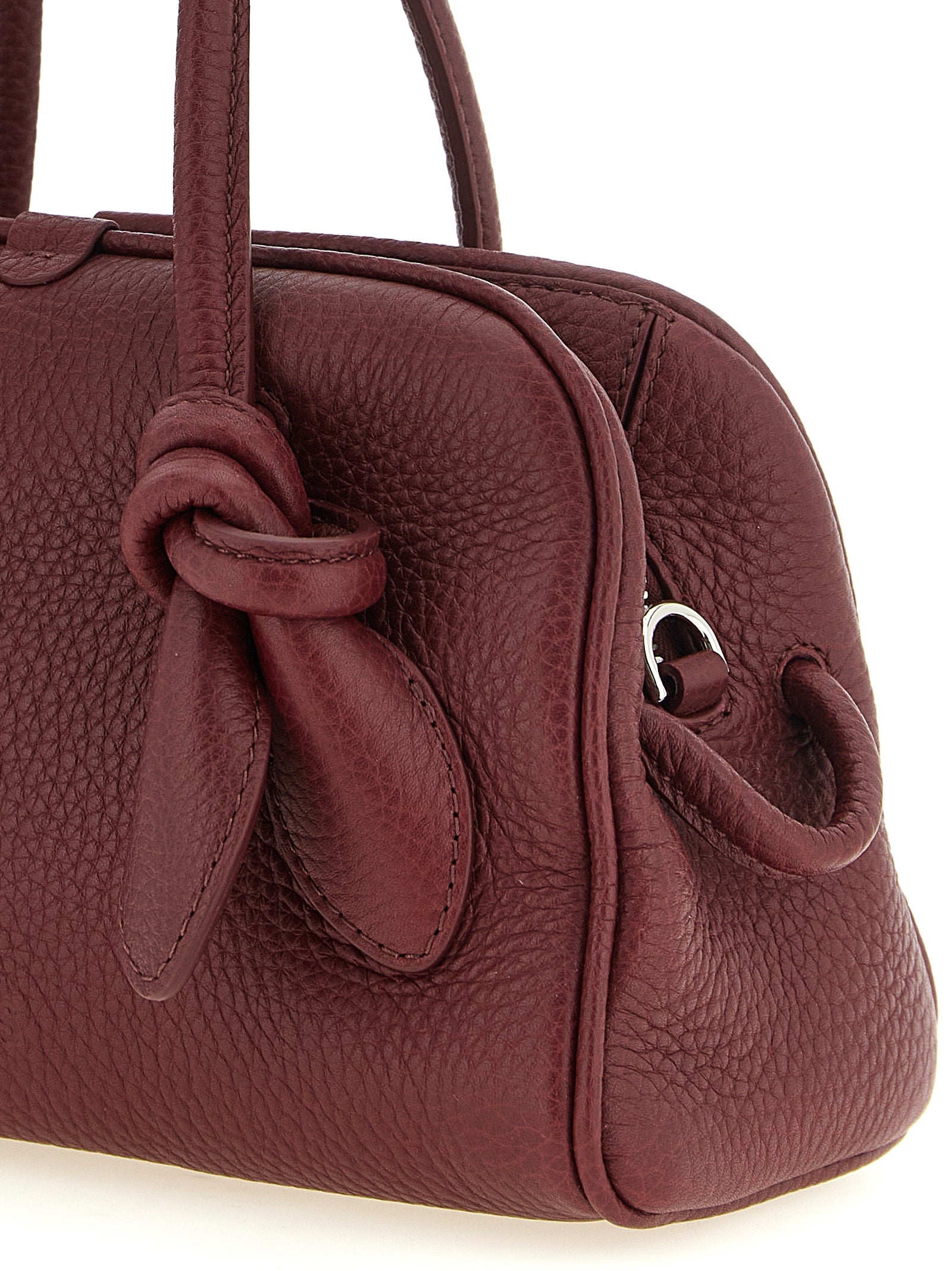 Indulge in the exquisite Jacquemus Le Petit Turismo handbag, a sculptural masterpiece of calfskin leather in rich Bordeaux, redefining luxury and elegance.