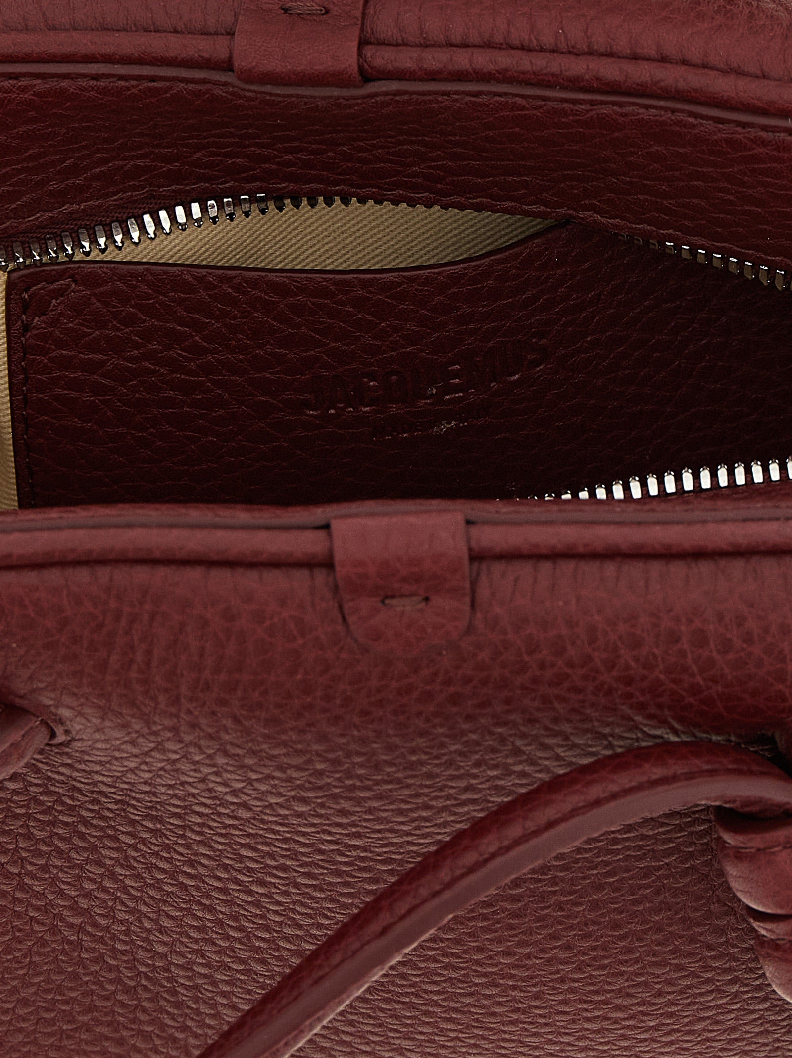 Indulge in the exquisite Jacquemus ‘Le Petit Turismo’ handbag, a sculptural masterpiece of calfskin leather in rich Bordeaux, redefining luxury and elegance for the discerning.