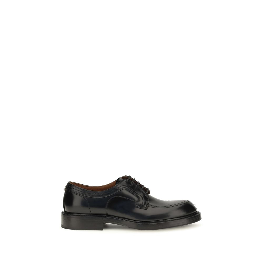 Indulge in the elegance of Dolce & Gabbana's Black Calf Leather Bos Taurus Oxfords, where refined craftsmanship meets timeless sophistication for the discerning individual.