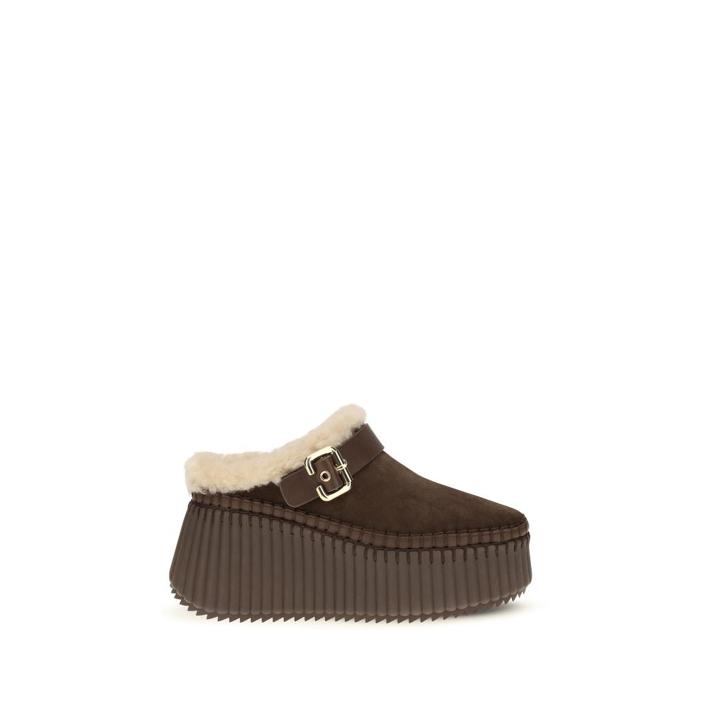 Experience the exquisite Chloé Brown Calf Leather Bos Taurus Mules, where sumptuous calf suede meets sustainable luxury, embodying timeless elegance for the discerning individual.