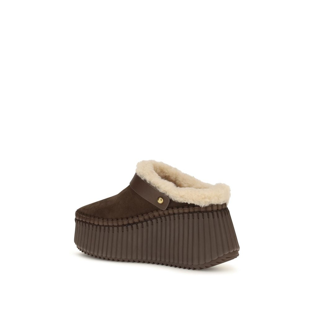 Indulge in the Chloé Brown Calf Leather Bos Taurus Mules, where exquisite craftsmanship meets sustainable luxury, elevating your style with timeless elegance and sophistication.