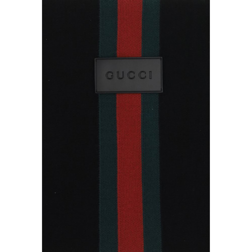 Experience the allure of the Gucci Black Wool Oves Aries Scarf, crafted from 100% Merino wool, embodying luxury and sophistication for every occasion.