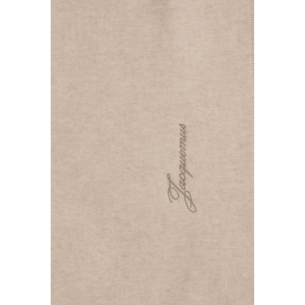 Indulge in the Jacquemus Beige Wool Oves Aries Scarf, a masterpiece of 100% Merino Wool, embodying elegance and sophistication for the discerning connoisseur.