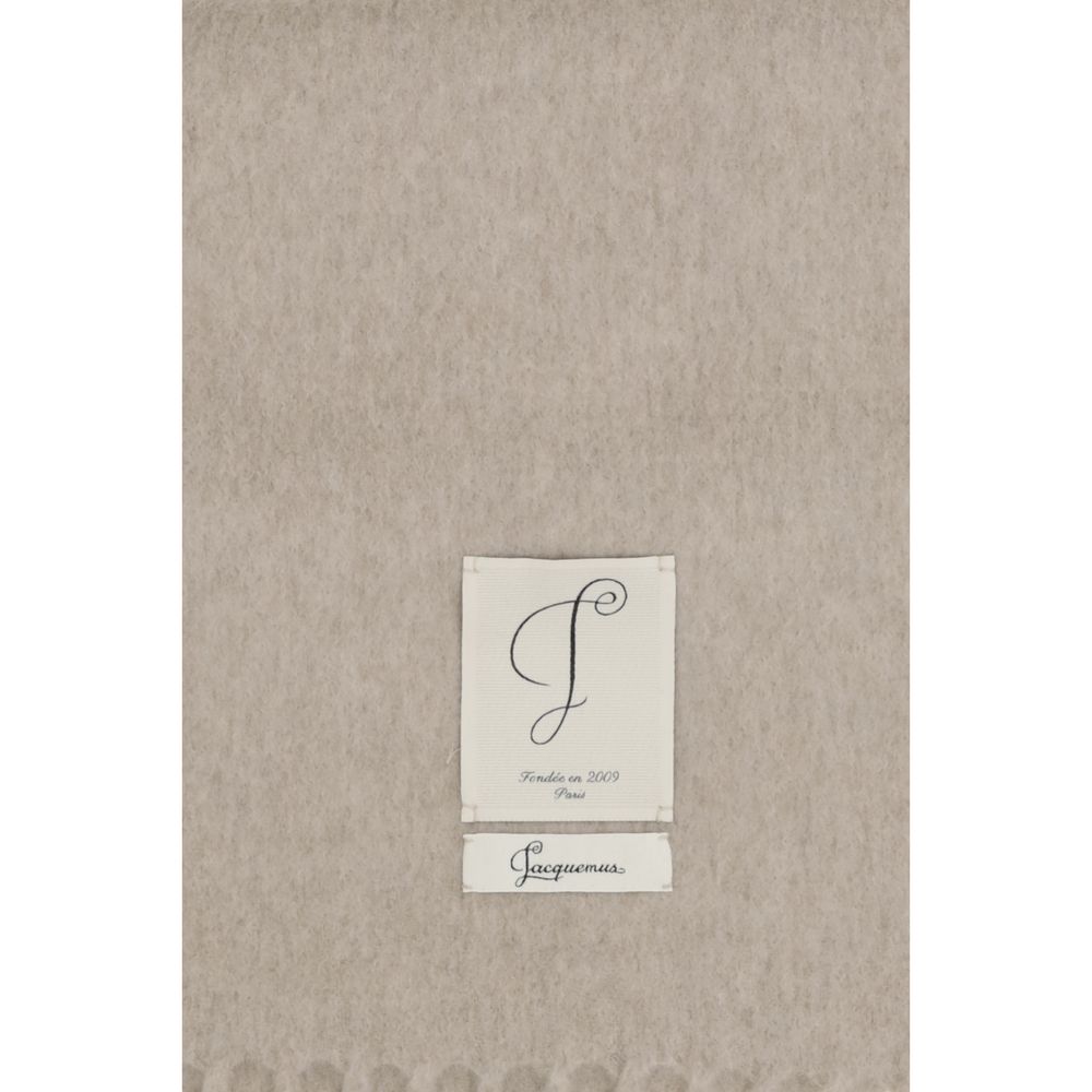 Elevate your style with the Jacquemus Beige Wool Oves Aries Scarf, a luxurious fleece wool masterpiece that embodies timeless elegance and sophisticated allure.