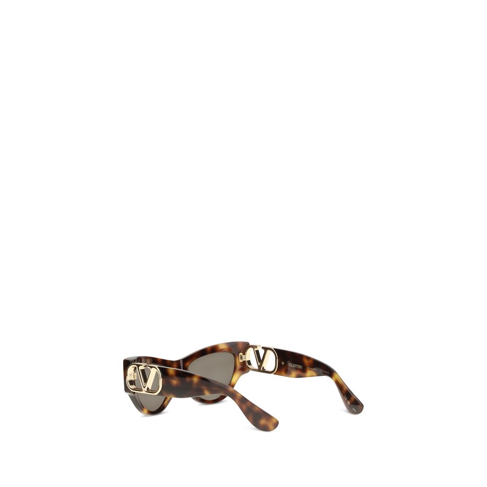 Indulge in the allure of Valentino Garavani Brown Acetate Sunglasses, crafted from glossy recycled acetate, merging sustainable luxury with timeless elegance for the discerning individual.