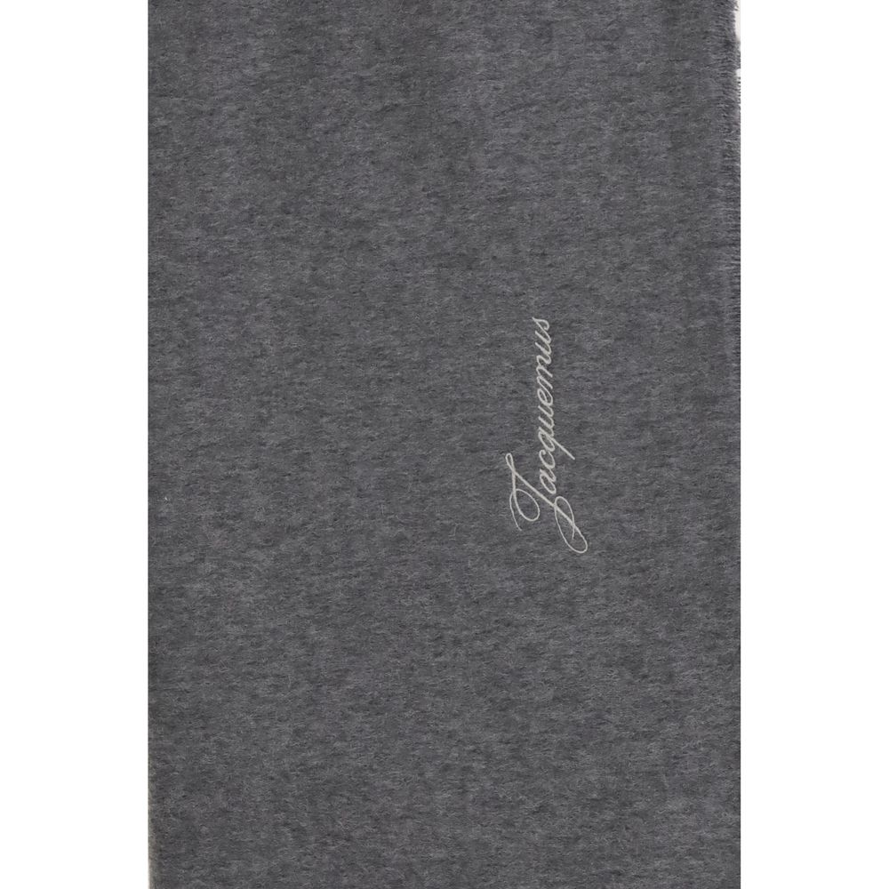 Experience the exquisite allure of the Jacquemus Gray Wool Oves Aries Scarf, crafted from 100% Merino wool, embodying timeless luxury and refined elegance for the discerning individual.