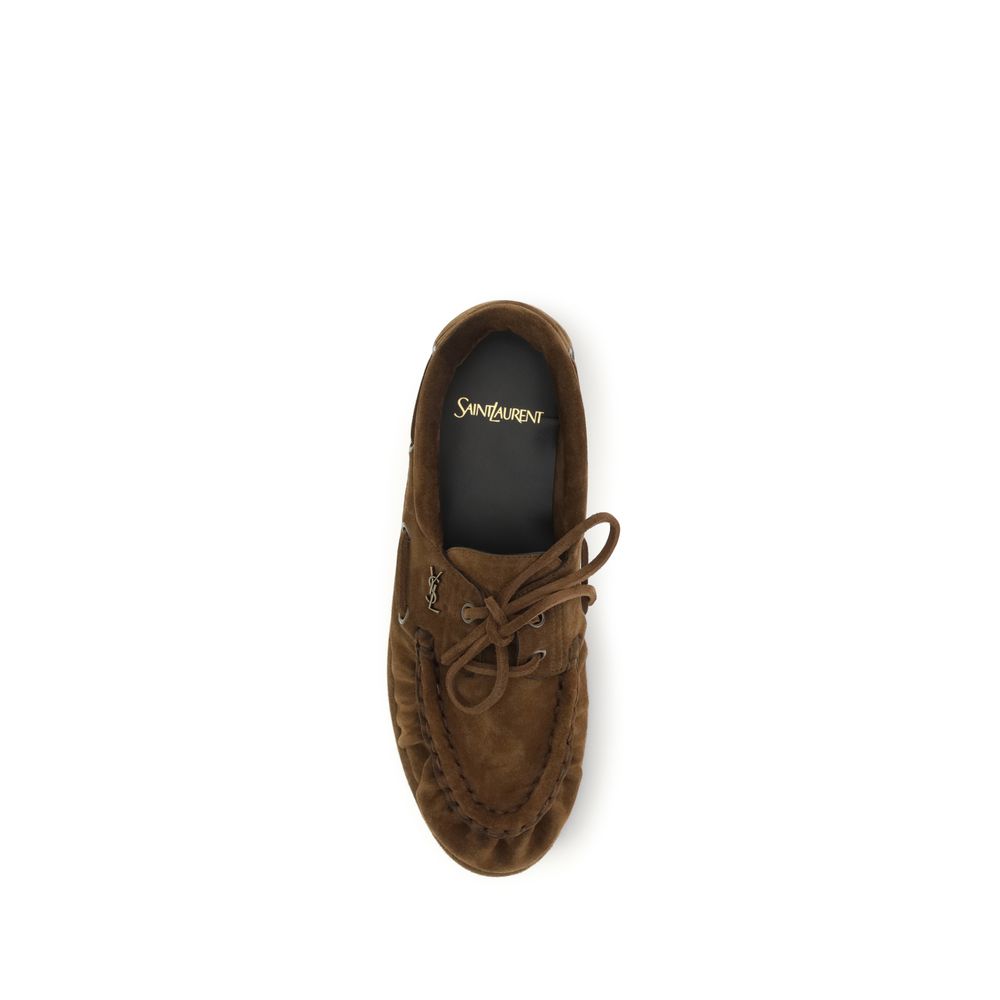 Discover the Saint Laurent Brown Suede Leather Slip-On Loafers, a masterpiece of artisanal craftsmanship and luxurious comfort, perfect for the discerning individual.