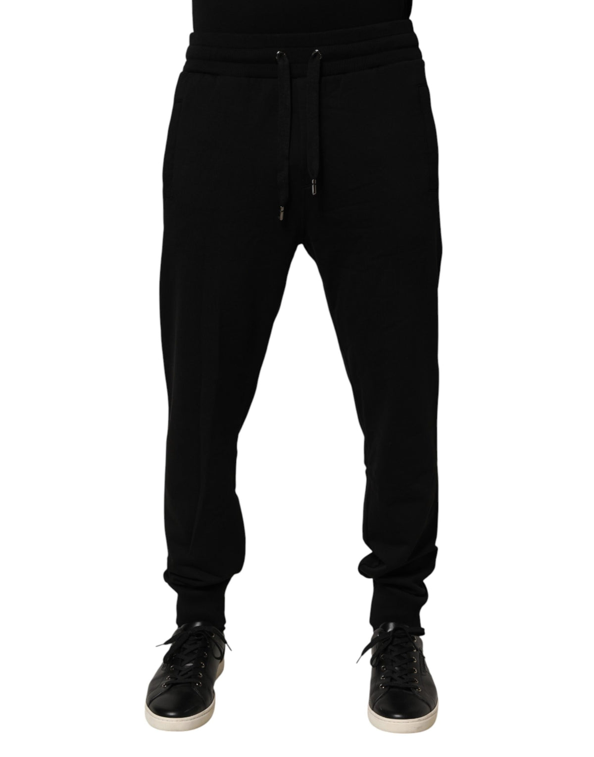Indulge in the exquisite craftsmanship of Dolce & Gabbana's black cotton jogger pants, where luxury meets effortless style, perfect for the discerning individual.