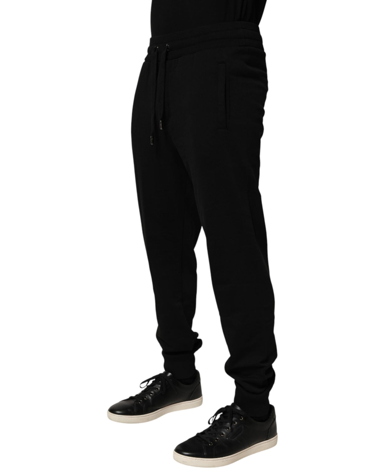 Indulge in the exquisite craftsmanship of Dolce & Gabbana's black cotton jogger pants, where luxury meets comfort, perfect for the discerning individual.