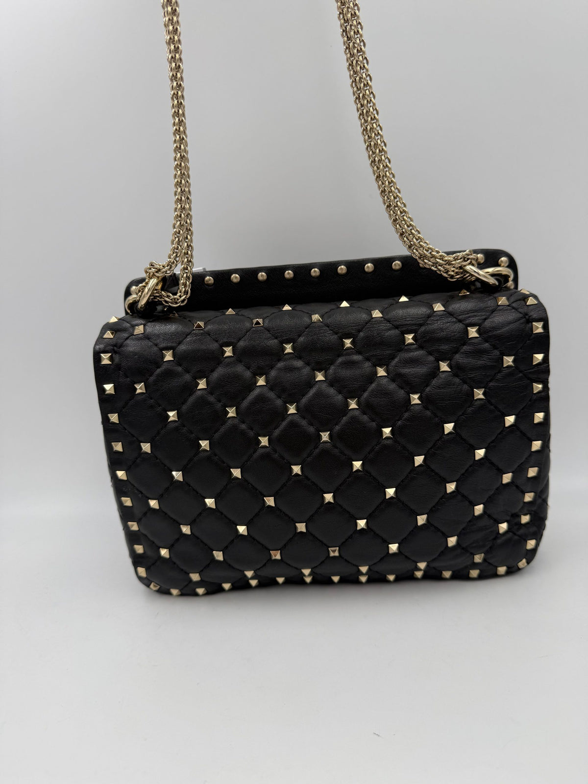Indulge in the elegance of the Valentino Garavani Rockstud Spike Black Handbag, where soft leather meets exquisite silver-tone studs, embodying timeless luxury and modern allure.