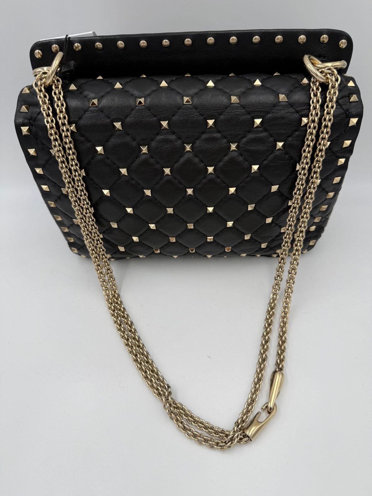 Indulge in the elegance of the Valentino Garavani Rockstud Spike Black Handbag, a masterpiece of Italian craftsmanship adorned with luxurious silver-tone studs, perfect for the discerning connoisseur.