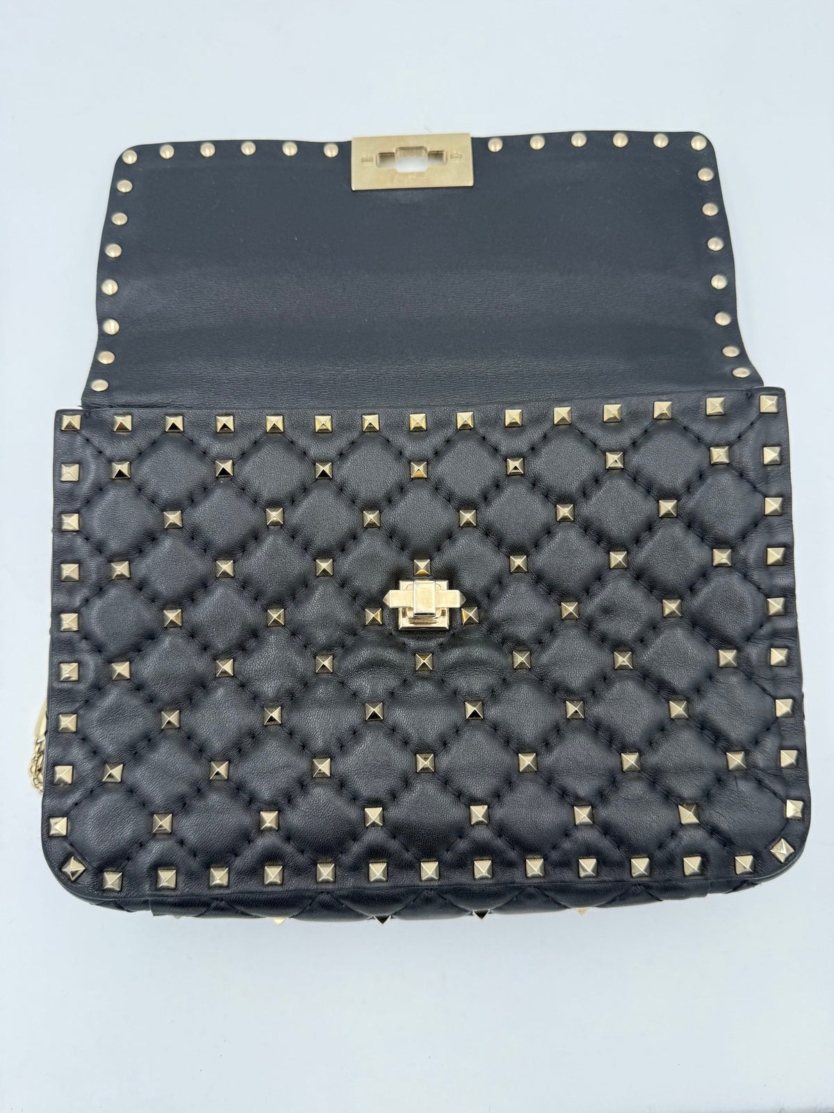 Indulge in the allure of the Valentino Garavani Rockstud Spike Black Handbag, a masterpiece of Italian craftsmanship that embodies elegance and timeless luxury.