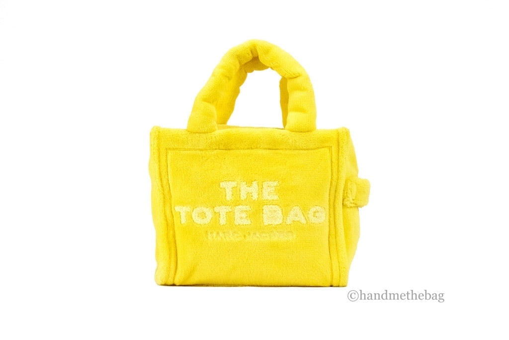 Elevate your style with Marc Jacobs The Terry Tote, a luxurious yellow mini crossbody crafted from soft terry fabric, embodying effortless elegance and modern sophistication.