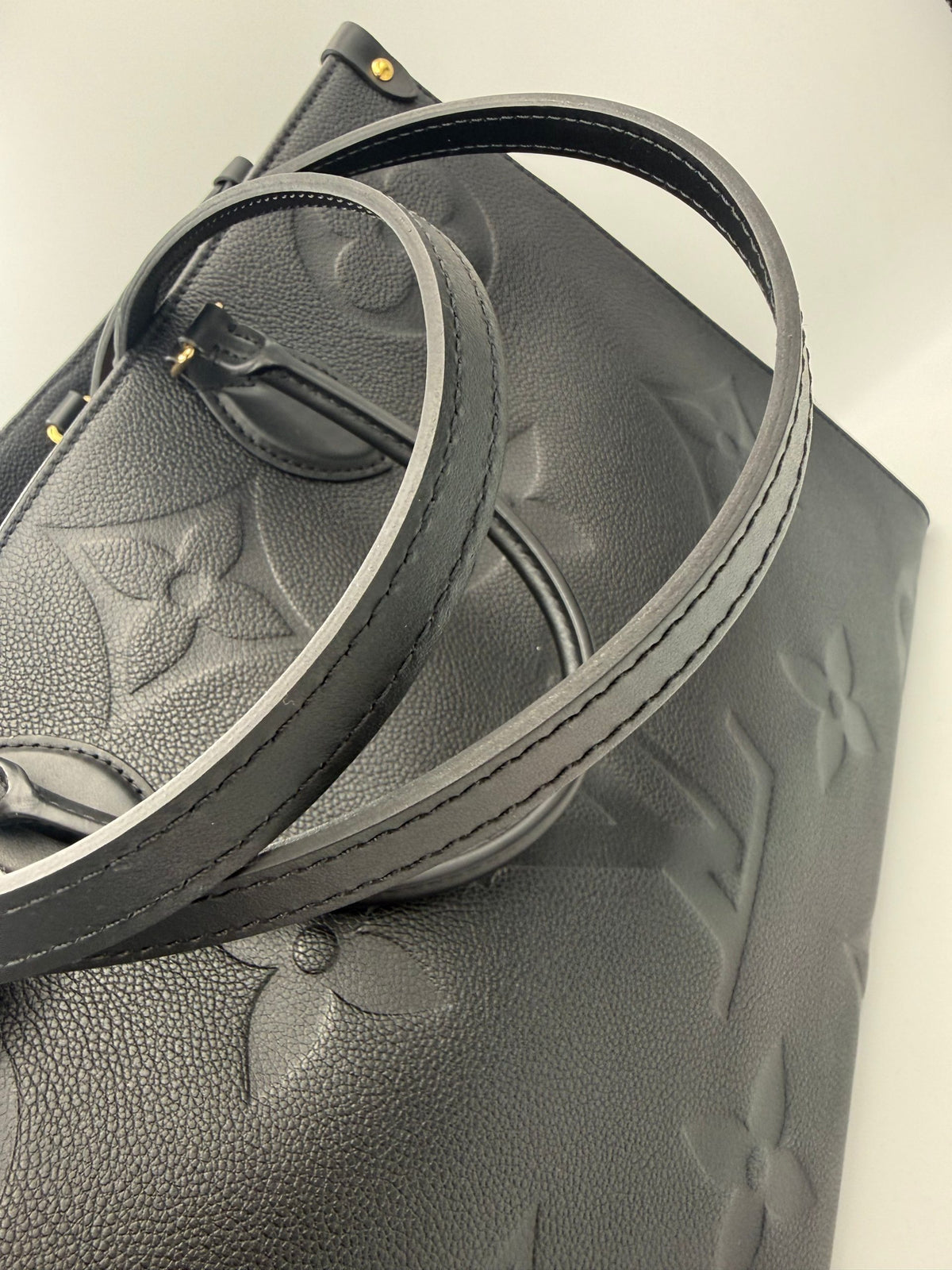 Elevate your style with the Louis Vuitton ON THE GO Empreinte GM Handbag, a luxurious blend of exquisite craftsmanship and timeless elegance, perfect for any occasion.