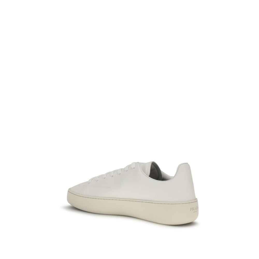 Indulge in the refined elegance of Prada's White Calf Leather Bos Taurus Low Top Sneakers, where impeccable craftsmanship meets modern luxury for the discerning individual.