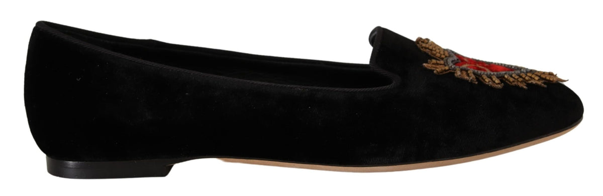 Experience the allure of Dolce & Gabbana's Black DG Sacred Heart Patch Slip On Flats, crafted from luxurious leather, embodying sophistication and timeless elegance for every occasion.