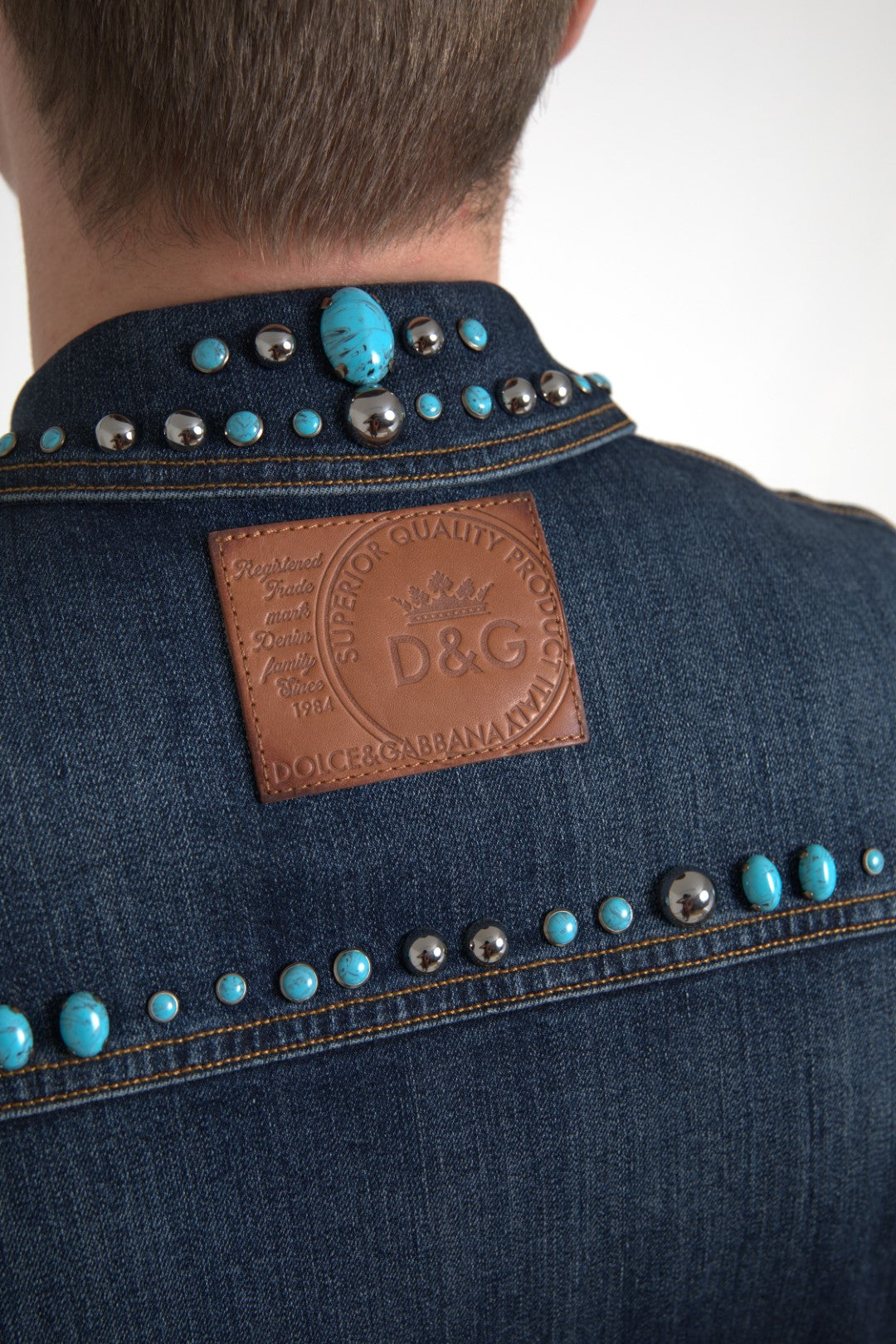 Indulge in the Dolce & Gabbana Blue Denim Turquoise Stones Studded Jacket, where exquisite craftsmanship meets iconic design, embodying timeless elegance and individuality.