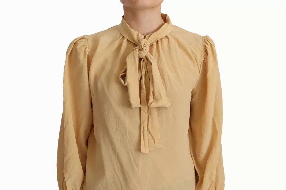 Indulge in the allure of the Dolce & Gabbana Mustard Ascot Collar Silk Blouse, a masterpiece of Italian craftsmanship that embodies timeless elegance and sophisticated luxury.
