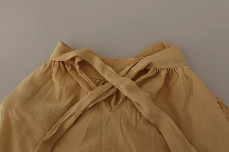 Indulge in the exquisite Dolce & Gabbana Mustard Ascot Collar Silk Blouse, a timeless piece of Italian craftsmanship that embodies luxury and sophistication for the discerning individual.