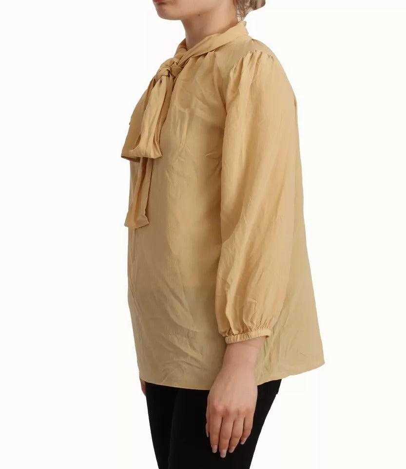 Indulge in the exquisite Dolce & Gabbana Mustard Ascot Collar Silk Blouse, a testament to Italian craftsmanship that redefines luxury and elegance for the discerning individual.