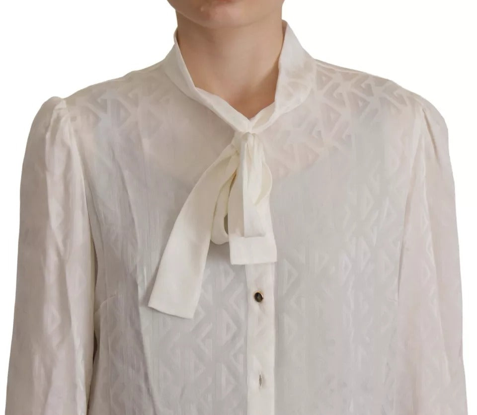 Indulge in the elegance of the Dolce & Gabbana White Patterned Silk Ascot Collar Blouse, a timeless piece crafted from luxurious silk, embodying sophistication and artistry.