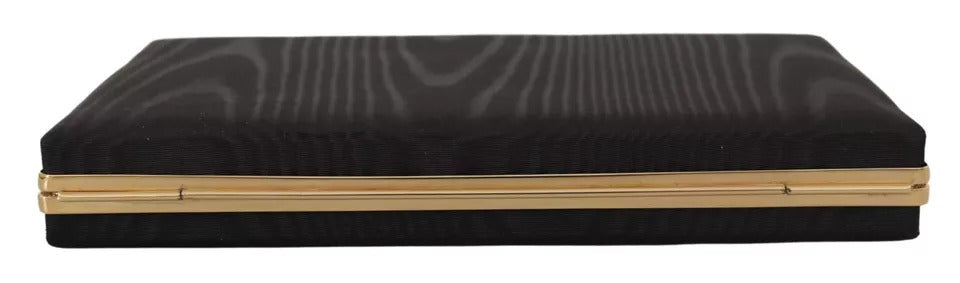 Indulge in the exquisite allure of the Dolce & Gabbana Black Silk Gold Frame Clutch, a timeless accessory that embodies luxury and Italian craftsmanship for the discerning individual.