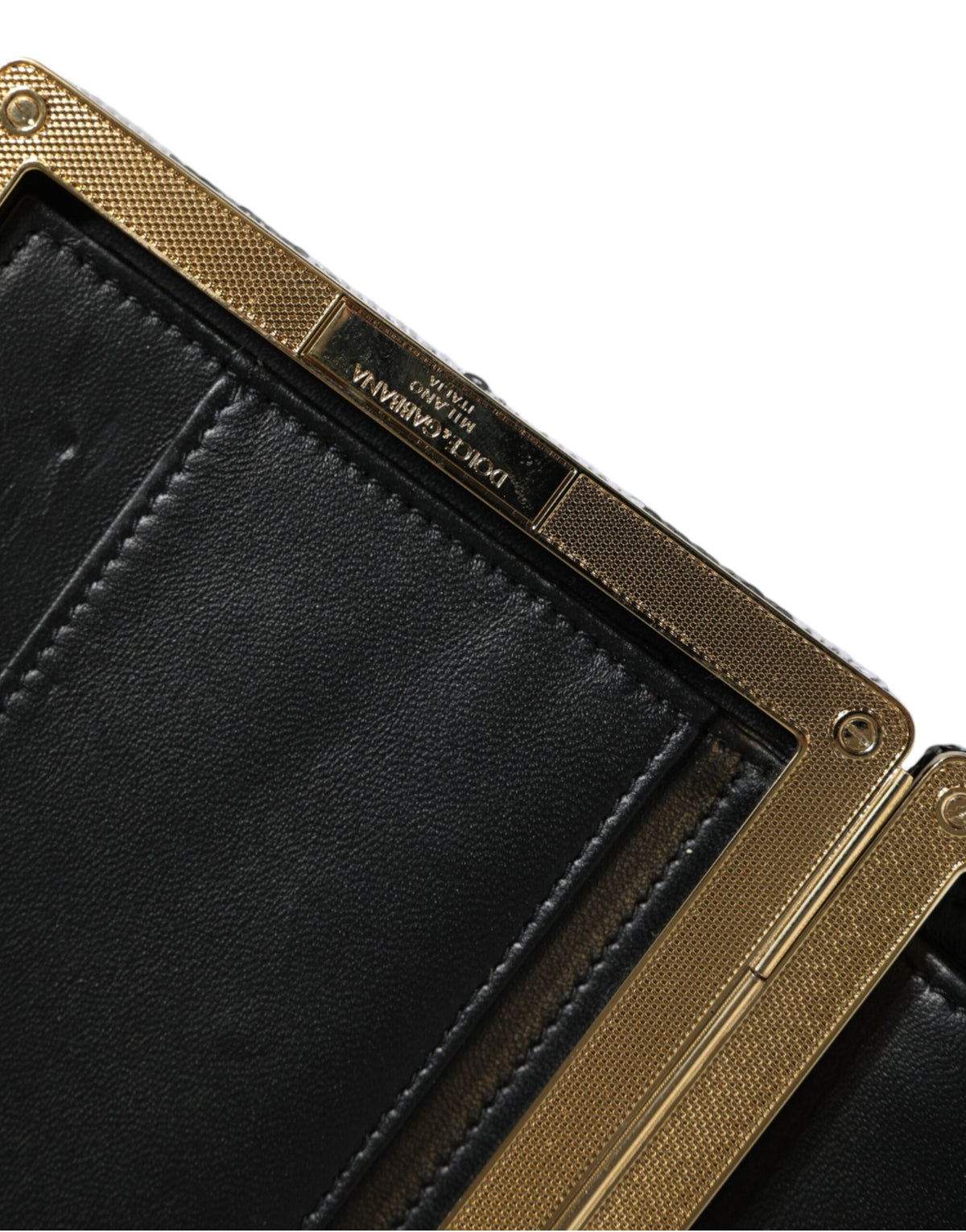 Discover the Dolce & Gabbana Black White Gold Frame Clutch, a masterpiece of Italian craftsmanship, merging luxurious materials for timeless elegance and allure.