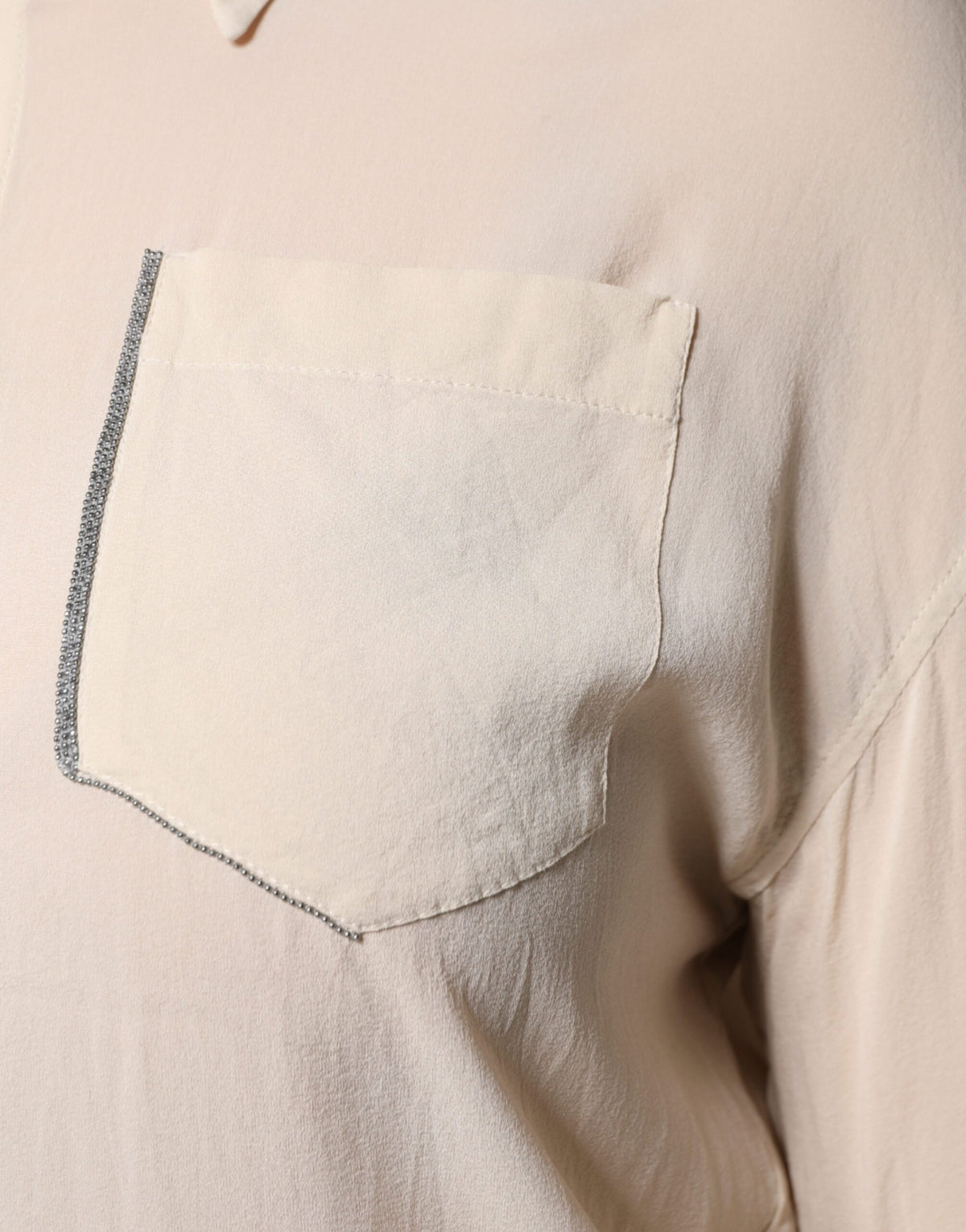 Indulge in the exquisite Brunello Cucinelli Beige Silk Blend Collared Button Down Top, a timeless piece that embodies luxury, artistry, and sophisticated elegance.