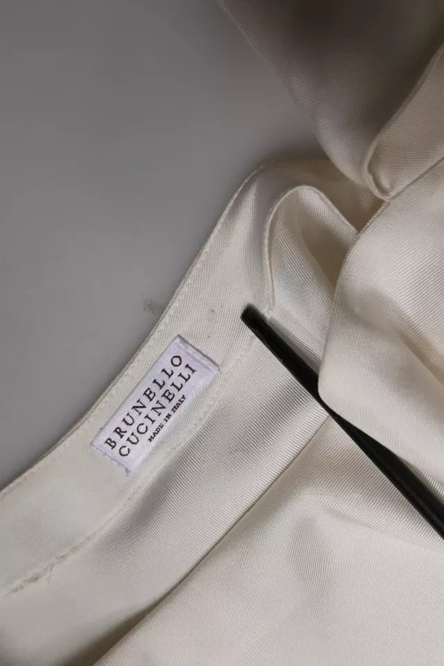 Indulge in the exquisite Brunello Cucinelli Beige Silk Ascot Collared Long Sleeves Top, where luxurious silk meets timeless elegance, perfect for the discerning individual.