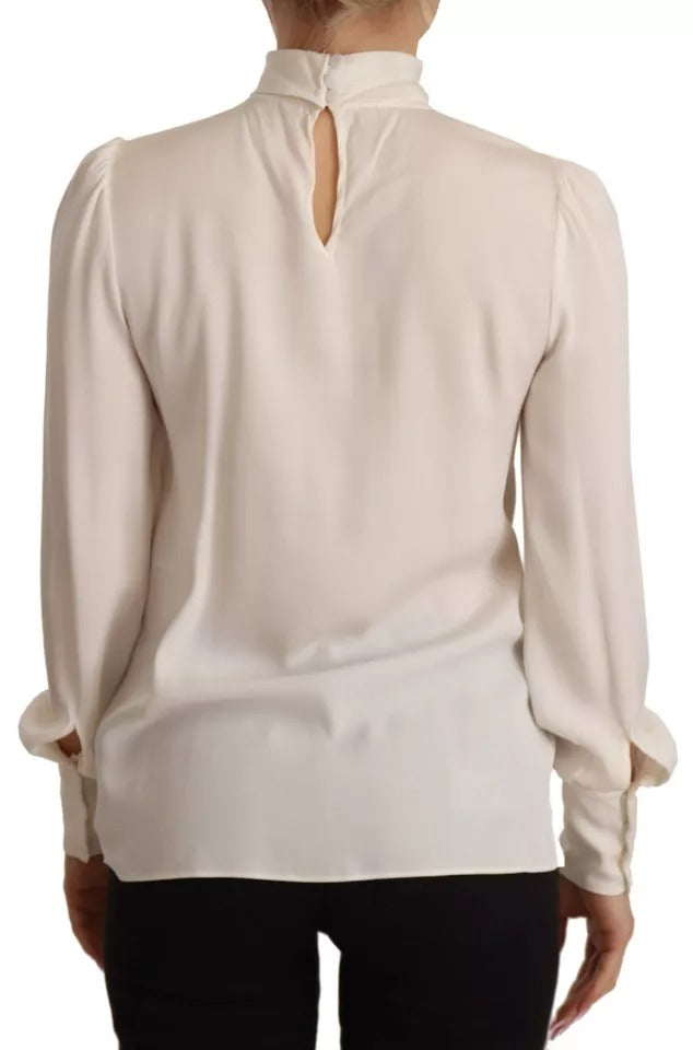 Indulge in the exquisite Dolce & Gabbana Off White Silk Long Sleeve Turtle Neck Top, a masterpiece of Italian craftsmanship that embodies luxury and elegance for every occasion.