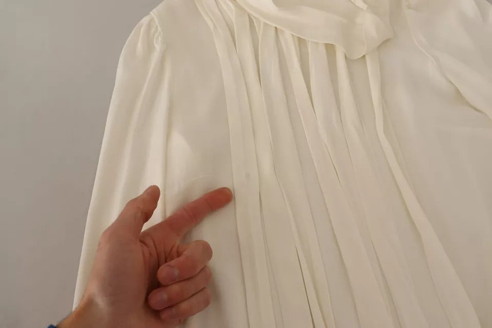 Indulge in the exquisite Dolce & Gabbana Off White Silk Long Sleeve Turtle Neck Top, a masterpiece of Italian craftsmanship that embodies elegance and sophistication for the discerning individual.