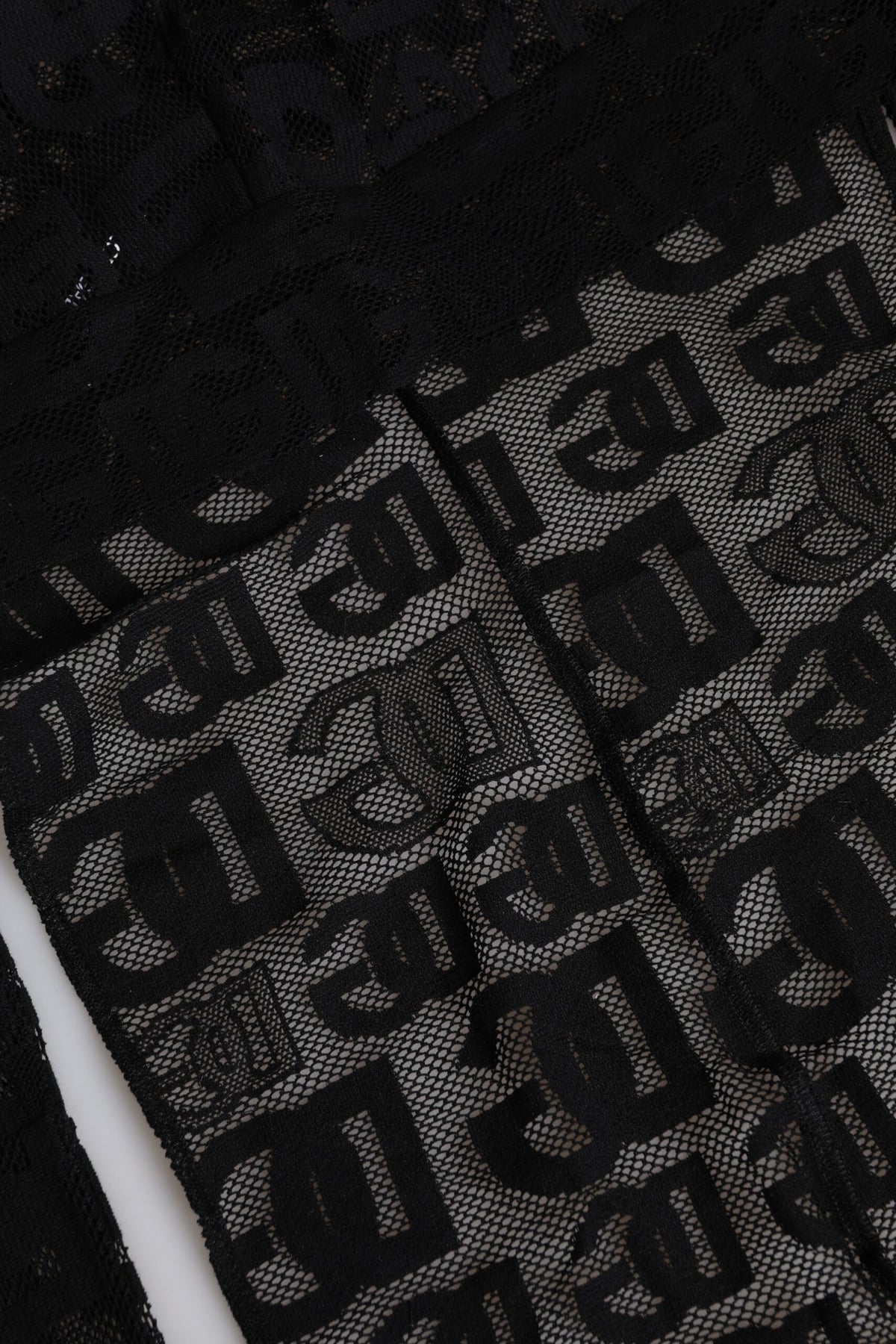Indulge in the Dolce & Gabbana Black Logo Mesh Whole Head Wrap Hat, a masterpiece of artisan luxury that elevates your style with exquisite craftsmanship and timeless elegance.
