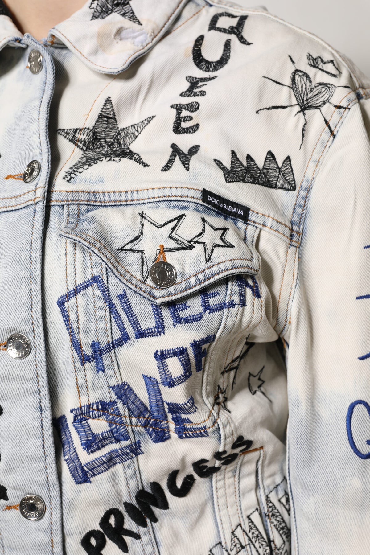 Elevate your wardrobe with the Dolce & Gabbana Light Blue Graffiti Button Down Denim Jacket, a luxurious blend of cotton and elastane, embodying artistry and sophistication for the discerning individual.