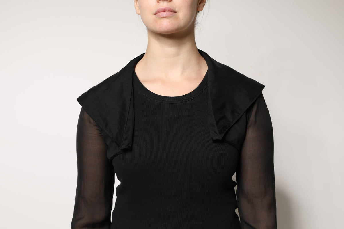 Indulge in the exquisite allure of the Dolce & Gabbana Black Silk Sheer Long Sleeves Blouse Top, a timeless masterpiece that embodies sensual elegance and sophisticated craftsmanship.