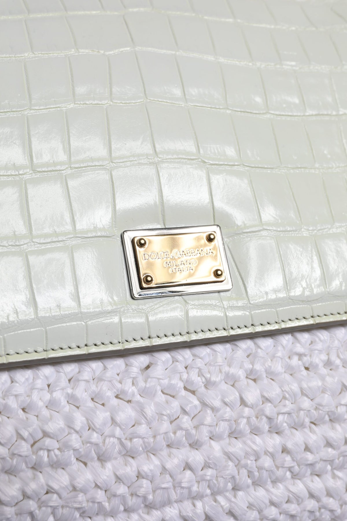 Discover the timeless elegance of the Dolce & Gabbana White Rafia Leather Top Handle Crossbody Bag, a luxurious statement piece crafted for the sophisticated individual.