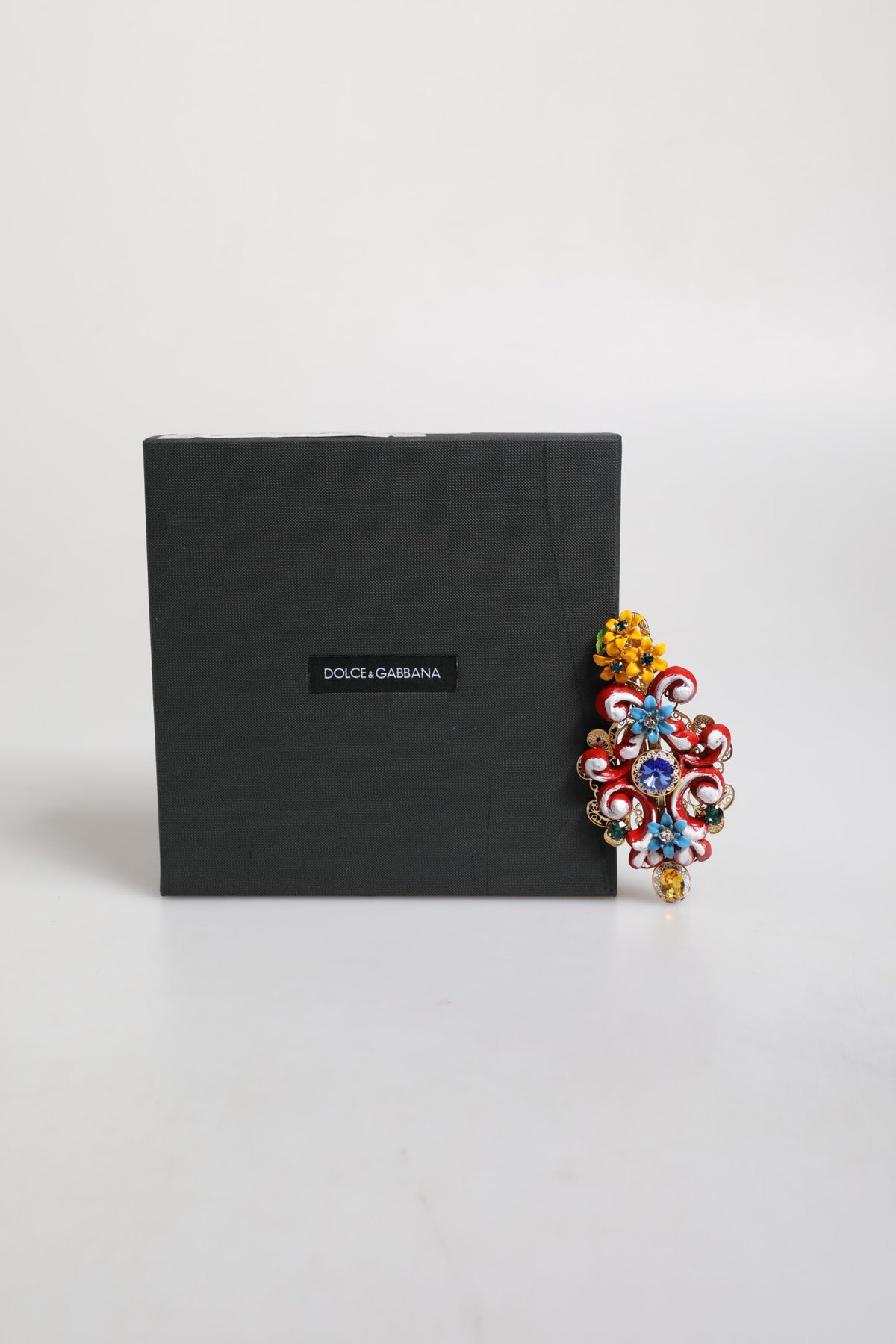 Discover the Dolce & Gabbana Multicolor Spring CARRETTO Hair Clip, a masterpiece of brass and crystal that embodies timeless elegance and exquisite craftsmanship.