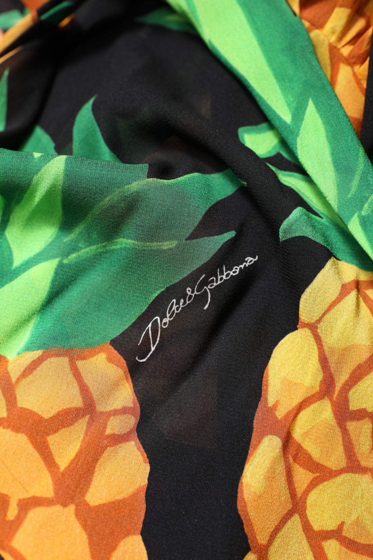 Experience the allure of Dolce & Gabbana's Black Silk Pineapple Draped Print Wrap Dress, where exquisite silk meets vibrant artistry, perfect for enchanting moments.
