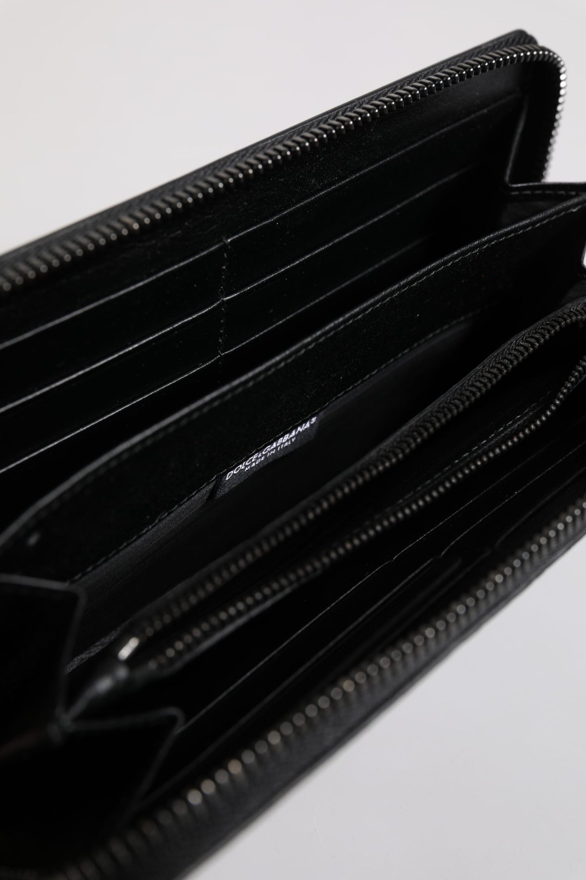 Experience the exquisite allure of the Dolce & Gabbana Black Leather Logo Plaque Zip Around Continental Wallet, a testament to Italian craftsmanship and timeless elegance.