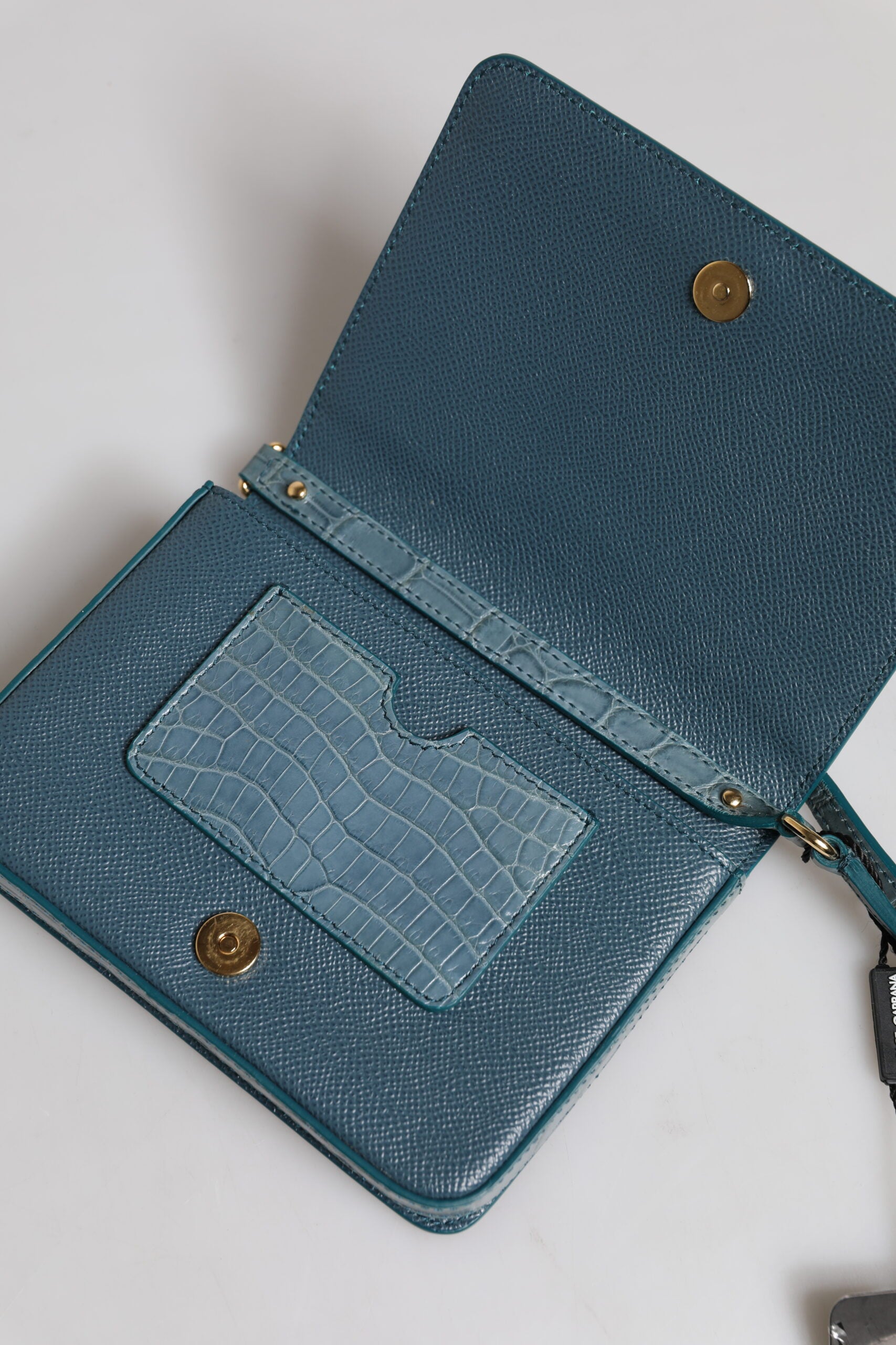 Discover the Dolce & Gabbana Green Exotic Leather DG Plaque Crossbody Mini Bag, a luxurious blend of crocodile and calf leather, epitomizing sophistication and timeless elegance.