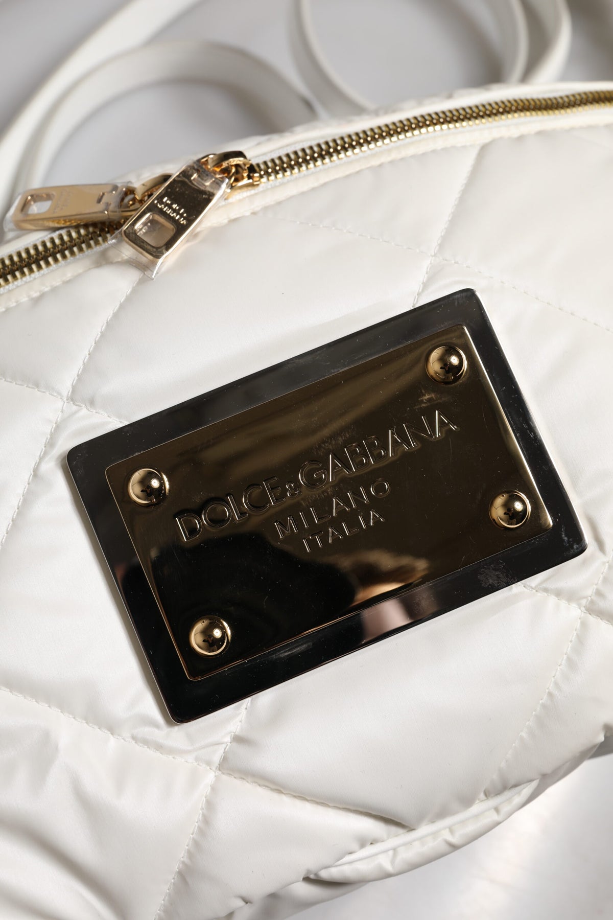 Elevate your style with the Dolce & Gabbana White Quilted Logo Plaque Fanny Pack Bag, a masterpiece of exquisite craftsmanship and timeless luxury, perfect for the discerning individual.
