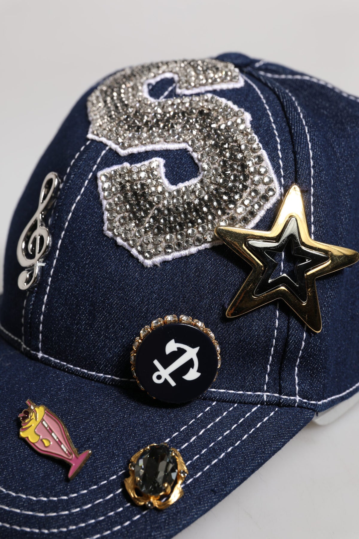 Experience the allure of the Dolce & Gabbana Blue Crystal Embellishment Baseball Cap, a masterpiece of Italian craftsmanship blending elegance and urban sophistication.