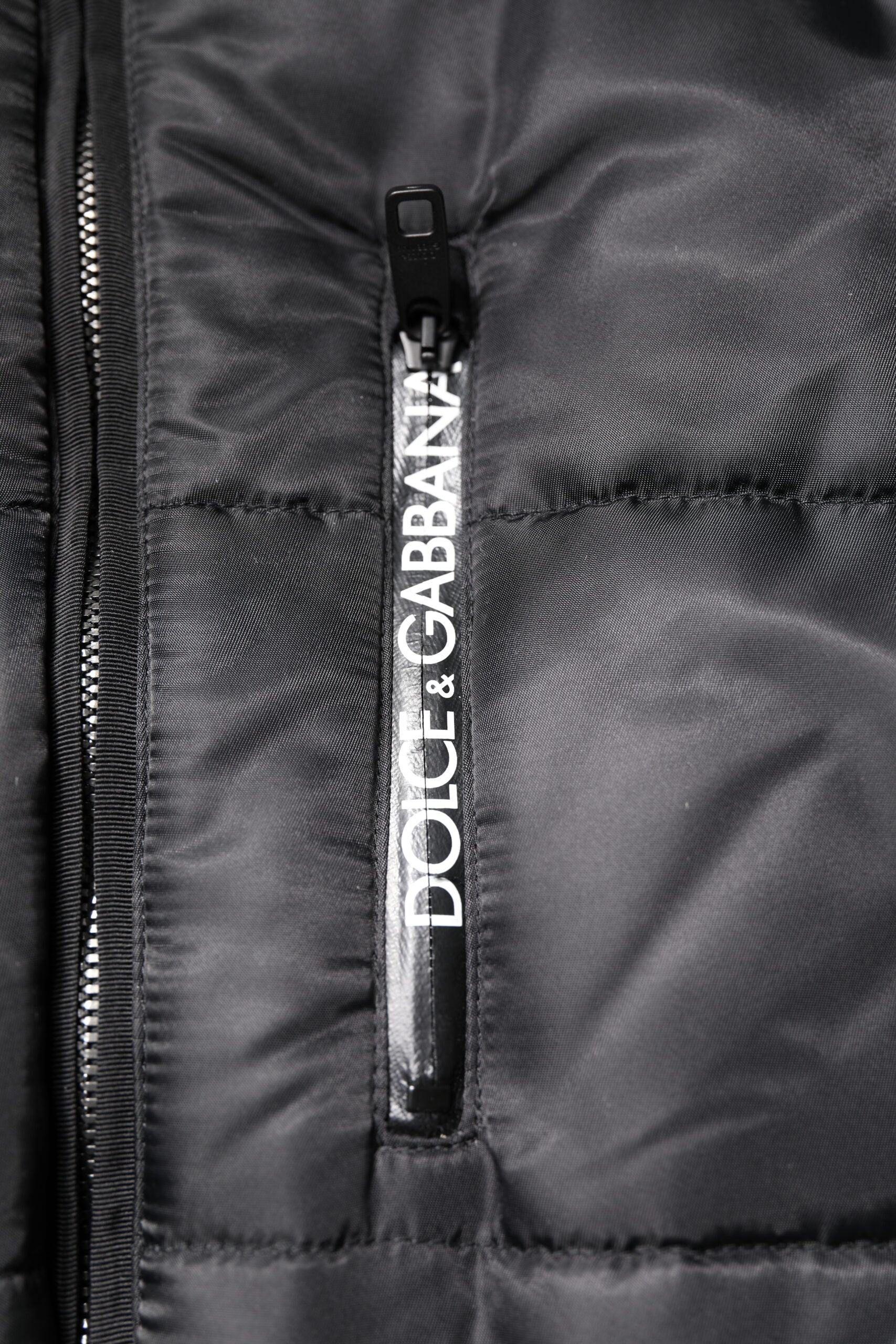 Elevate your winter wardrobe with the Dolce & Gabbana Black Hooded Parka, a luxurious blend of nylon and cotton, embodying timeless sophistication and Italian craftsmanship.