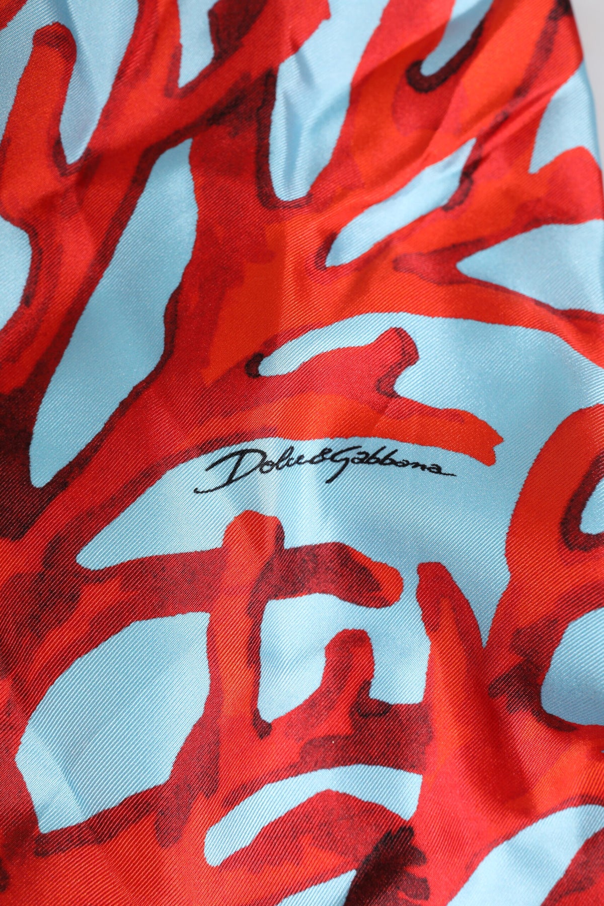 Indulge in the exquisite Dolce & Gabbana Blue Red Coral Print Wrap Robe Coat Jacket, a silk masterpiece that embodies timeless elegance and sophisticated allure.