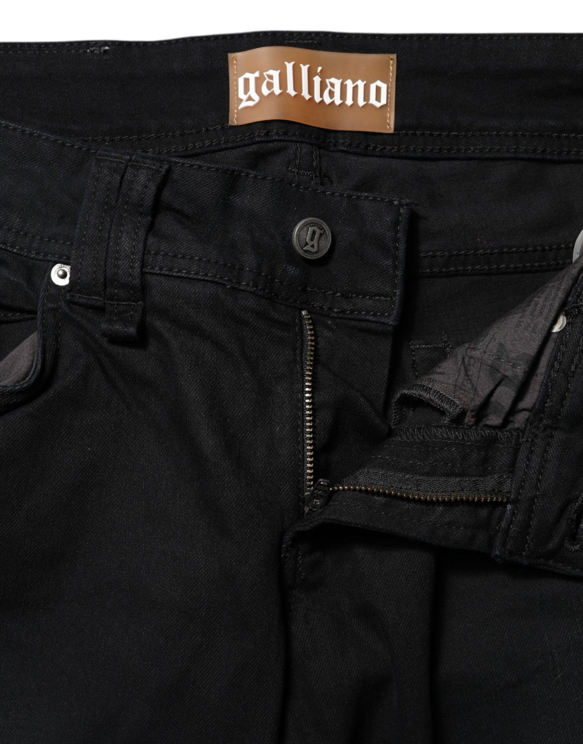 Indulge in the exquisite craftsmanship of John Galliano's Black Cotton Mid Waist Tapered Denim Jeans, where luxurious comfort meets timeless elegance for every occasion.
