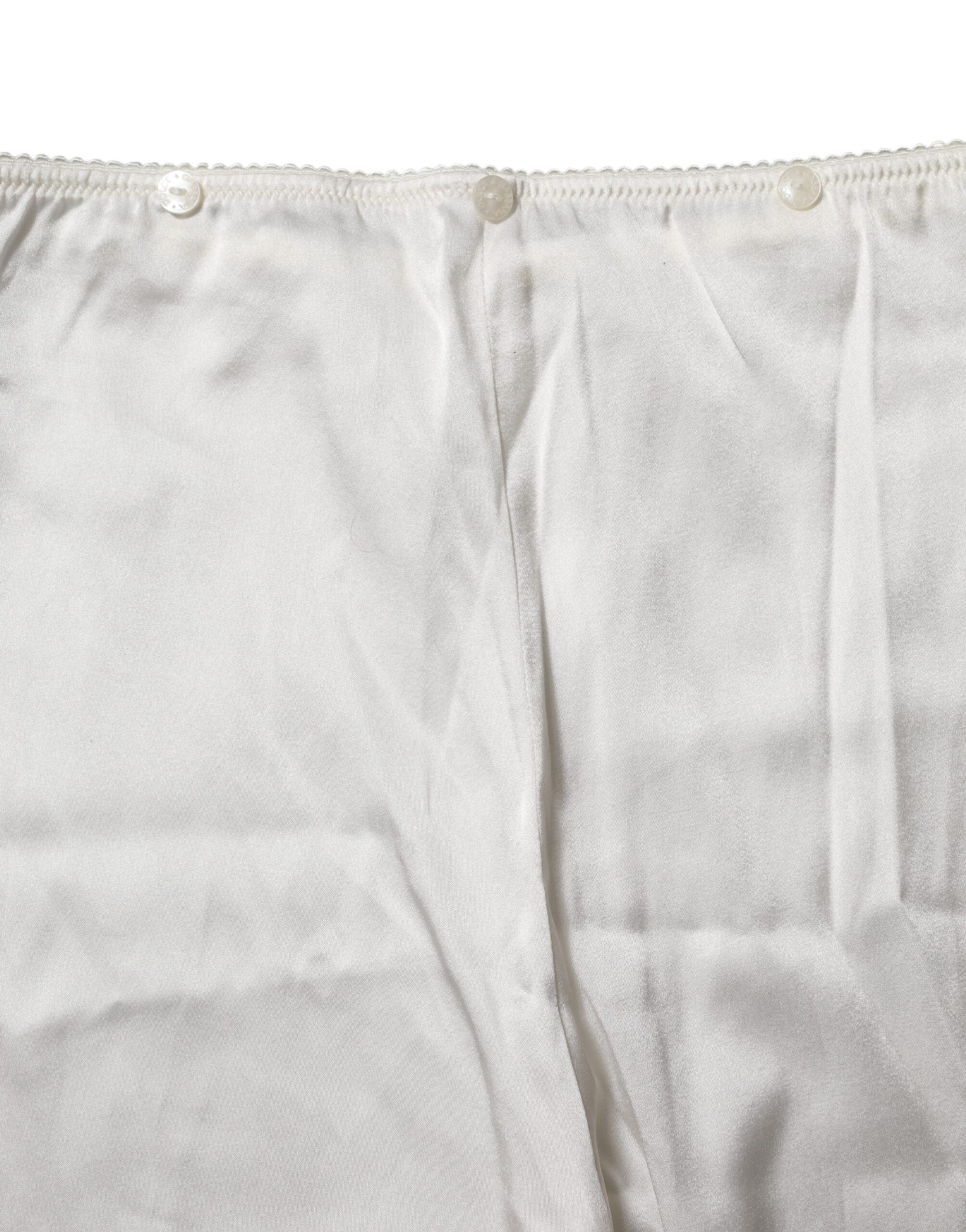 Indulge in the exquisite Dolce & Gabbana Ivory Silk Tapered High Waist Pants, a testament to Italian craftsmanship that elevates your elegance and allure.