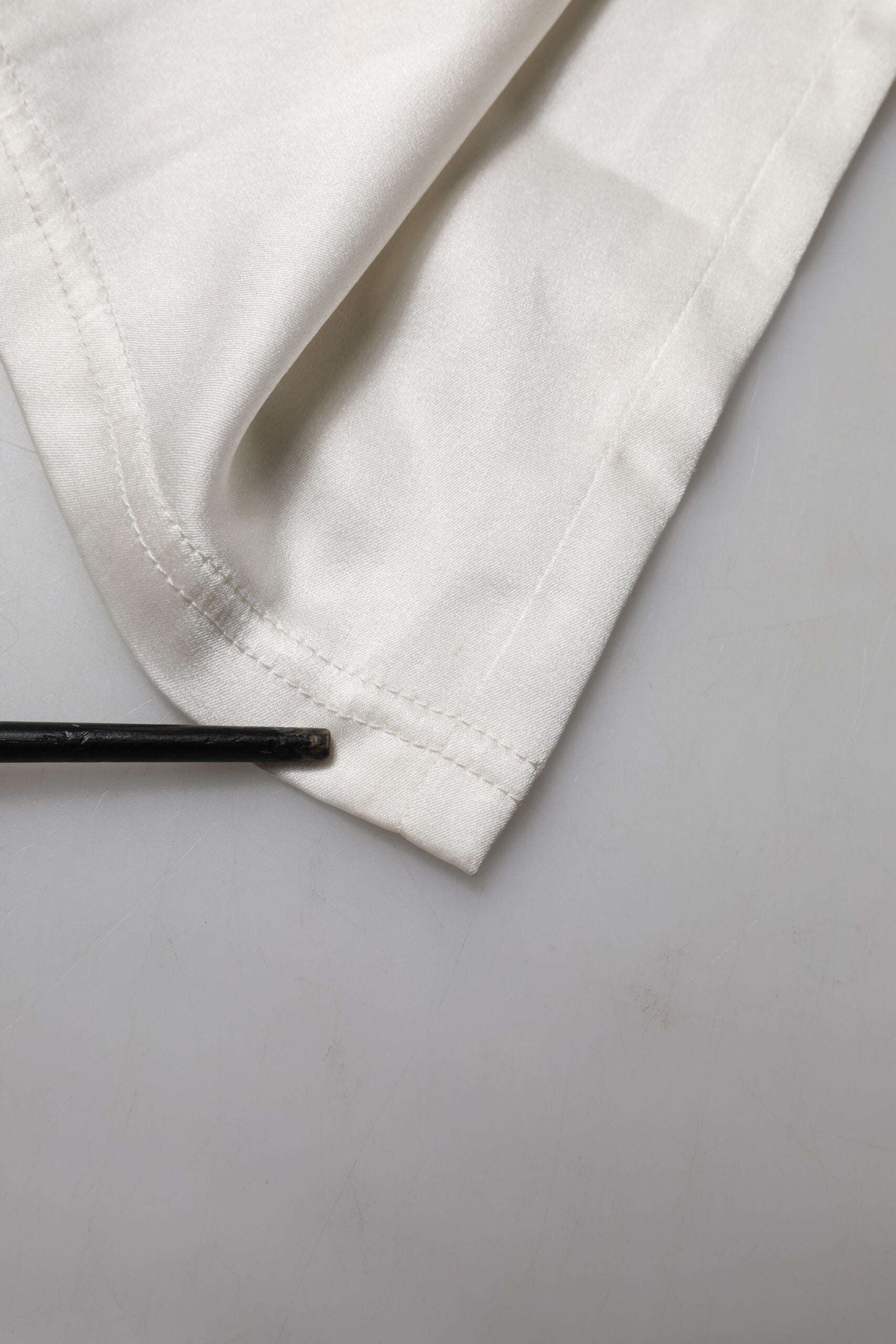 Indulge in the exquisite allure of Dolce & Gabbana's Ivory Silk Tapered High Waist Pants, a testament to luxurious craftsmanship and timeless elegance for the discerning individual.